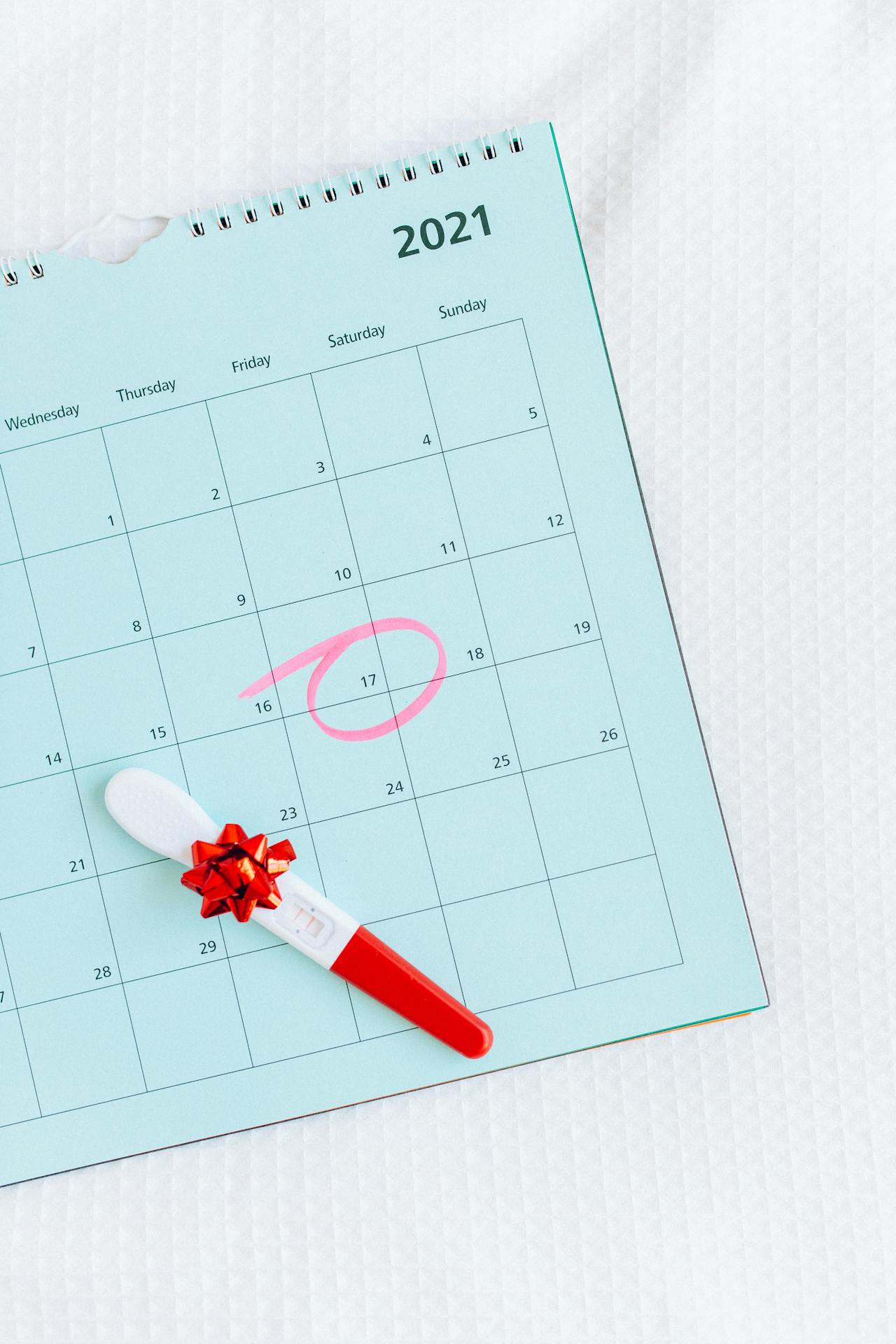 Calendar with a circled date and a pregnancy test