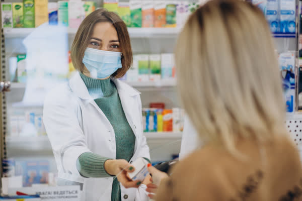Pharmacist serving a customer at the counter