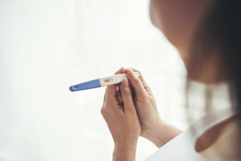 Woman holding a positive pregnancy test