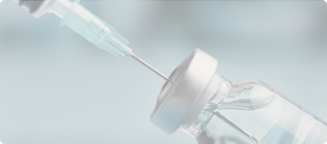 Syringe drawing vaccine from a vial